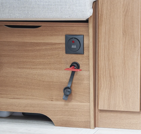 Roter Kunststoffschlüssel steckt im Trennschalter in einem Camper